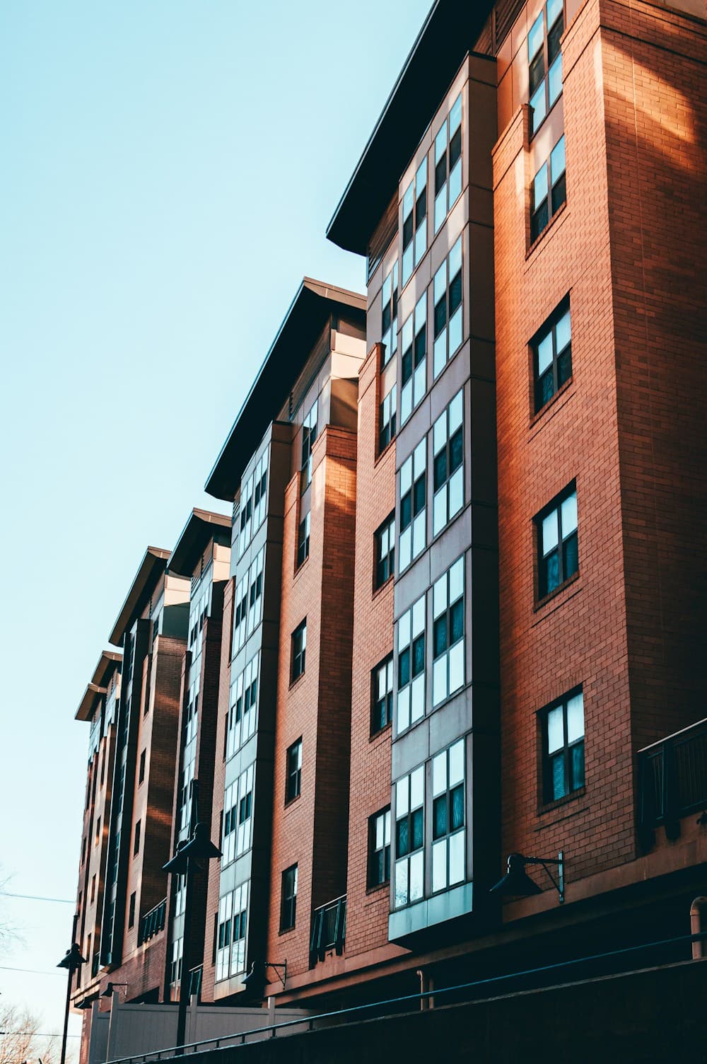 Illustrative location photograph of a brick building in warm sunlight